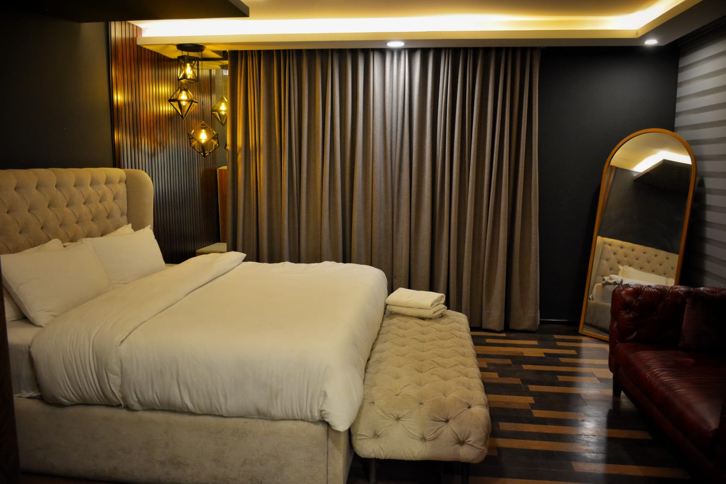 Beige tufted bed with pendant lights